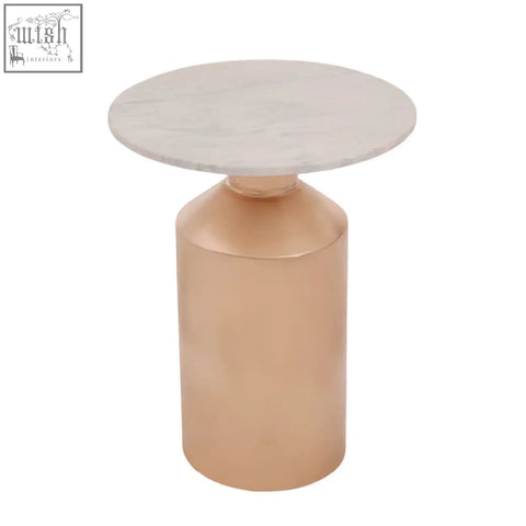 A sleek amira marble side table with a gold base featuring a copper finish and a round white marble top