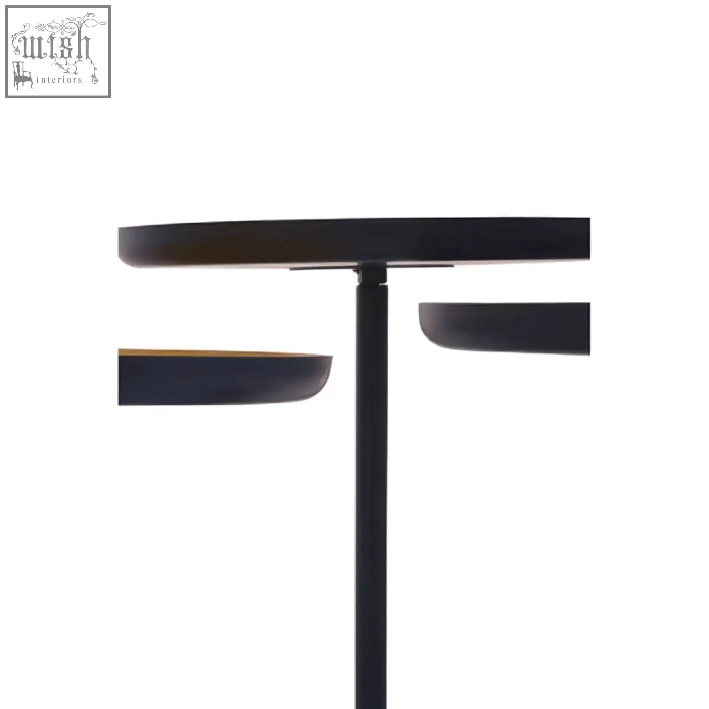 Black minimalist floor lamp with sleek cylindrical base and circular shade next to three gold and black tray tables