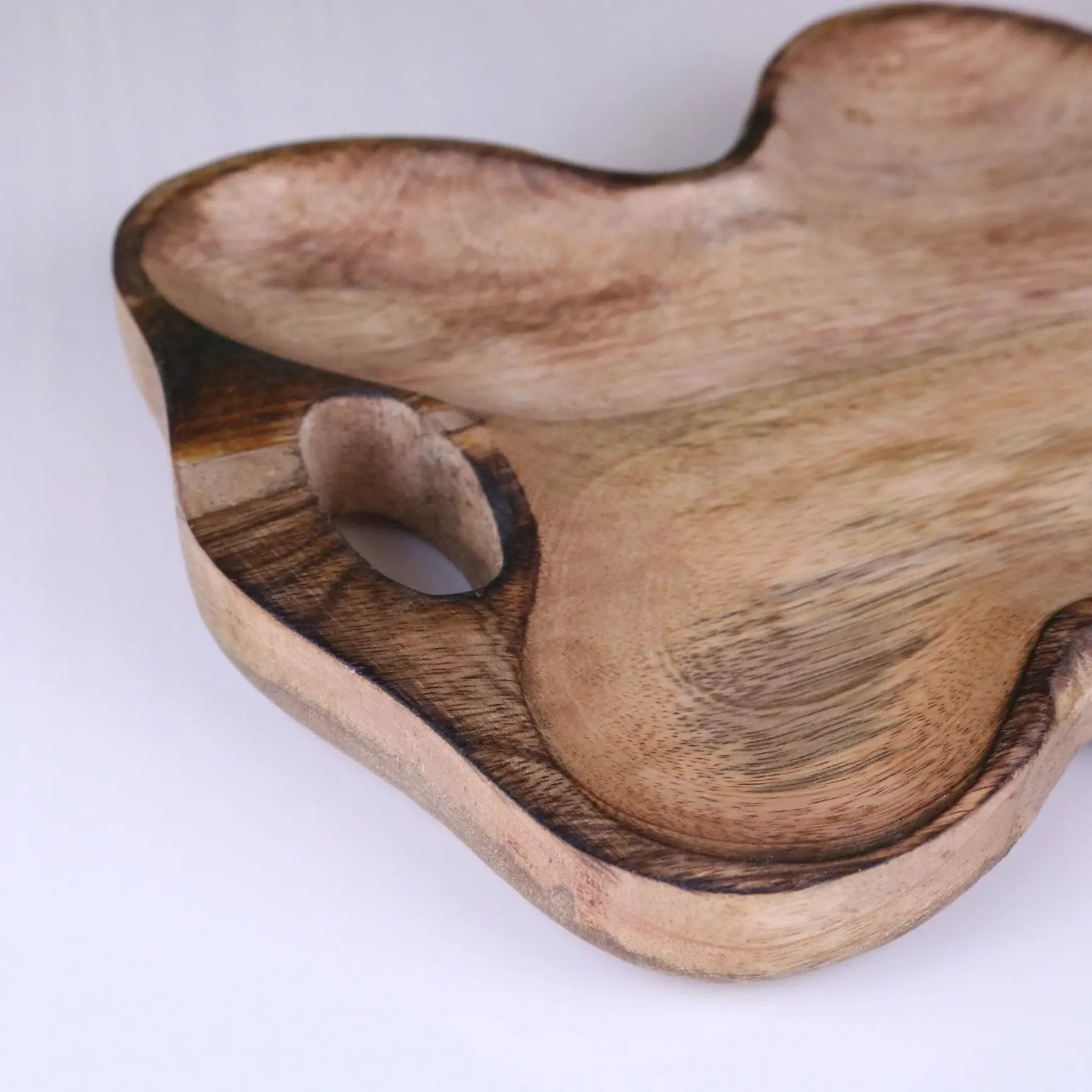 Handcrafted amrola mango wood serving dish with natural light brown finish and organic irregular edges wood serving tray