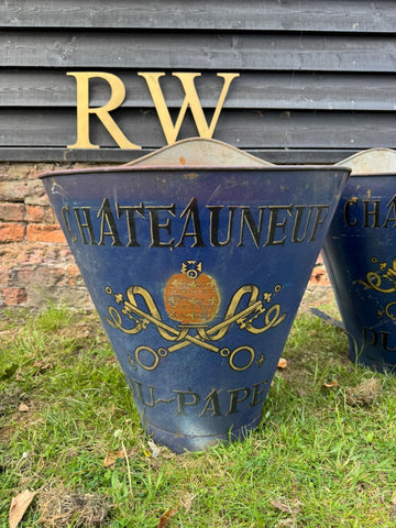Deep blue metal watering can with gold lettering and châteauneuf du pape crest in vintage french grape hod set