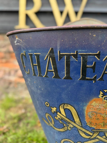 A vintage blue metal wine cooler with gold lettering and ornate designs from an antique french grape hod planter set