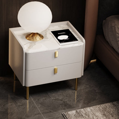 Modern white marble-top ana bedside table with gold-tone legs and drawer pulls in a sleek minimalist design