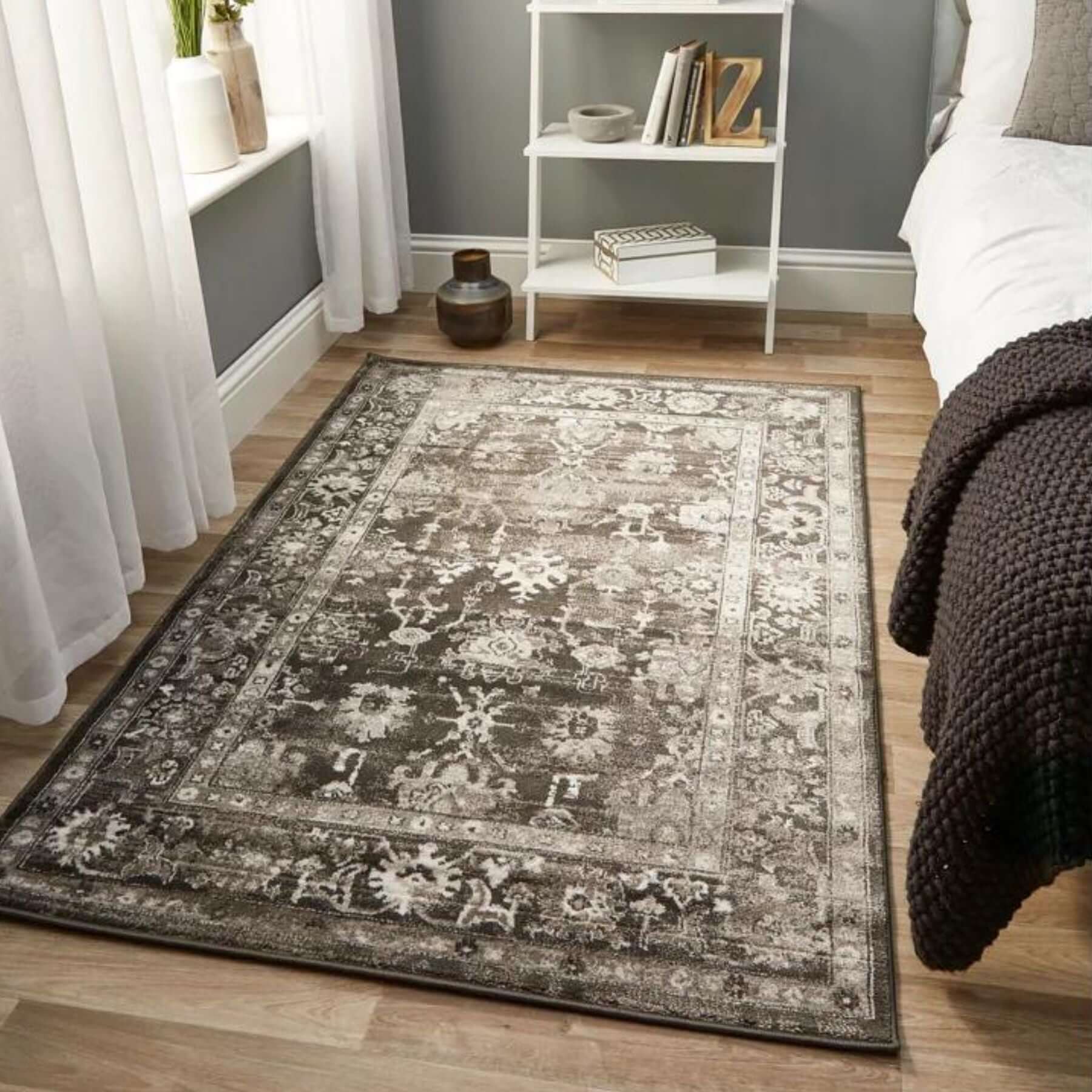 A rectangular anatolia dark grey vintage rug with a faded gray and white floral pattern on soft-textured surface