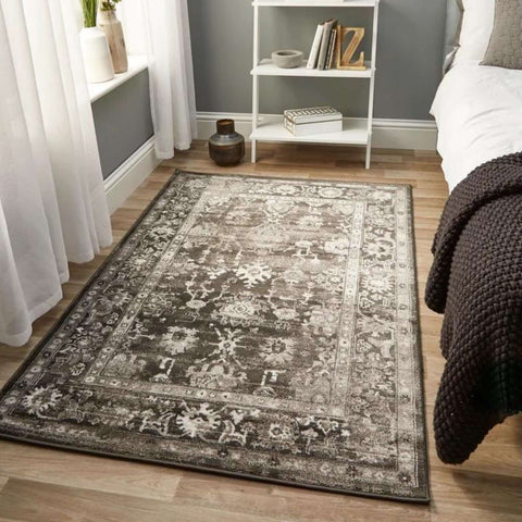 A rectangular anatolia dark grey vintage rug with a faded gray and white floral pattern on soft-textured surface
