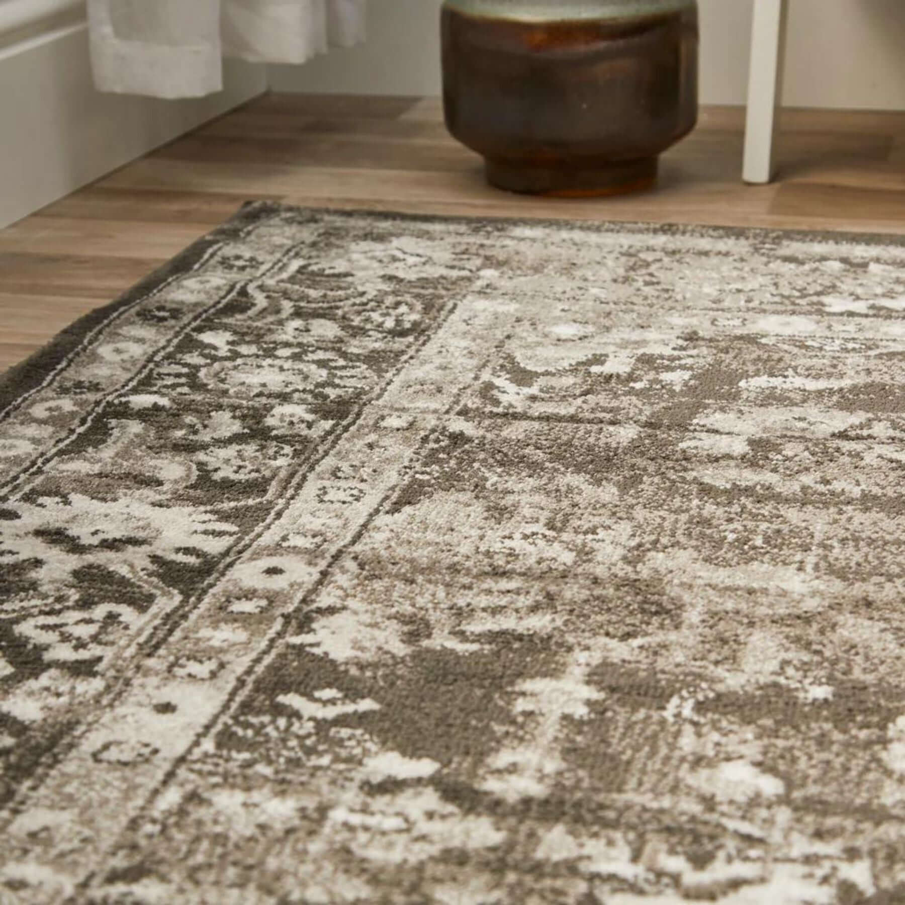 A vintage-style anatolia dark grey rug with a distressed faded pattern in shades of grey and white