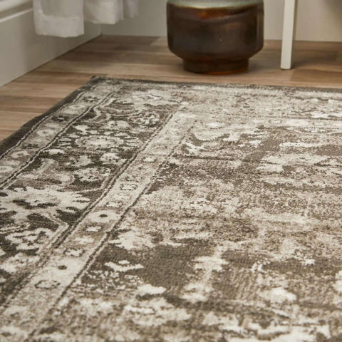 A vintage-style anatolia dark grey rug with a distressed faded pattern in shades of grey and white