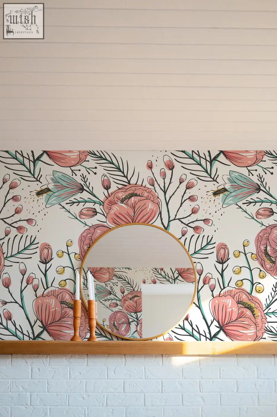 Round gold-framed mirror on wooden shelf against pink anemone fall peel and stick floral wallpaper for living space