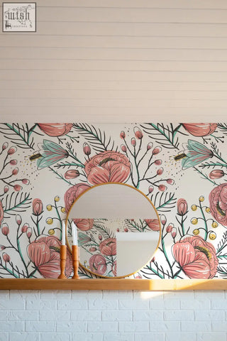 Round gold-framed mirror on wooden shelf against pink anemone fall peel and stick floral wallpaper for living space
