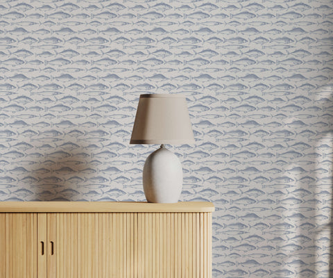 A sleek white ceramic table lamp with a beige fabric shade on a light wood cabinet perfect for fish wallpaper decor