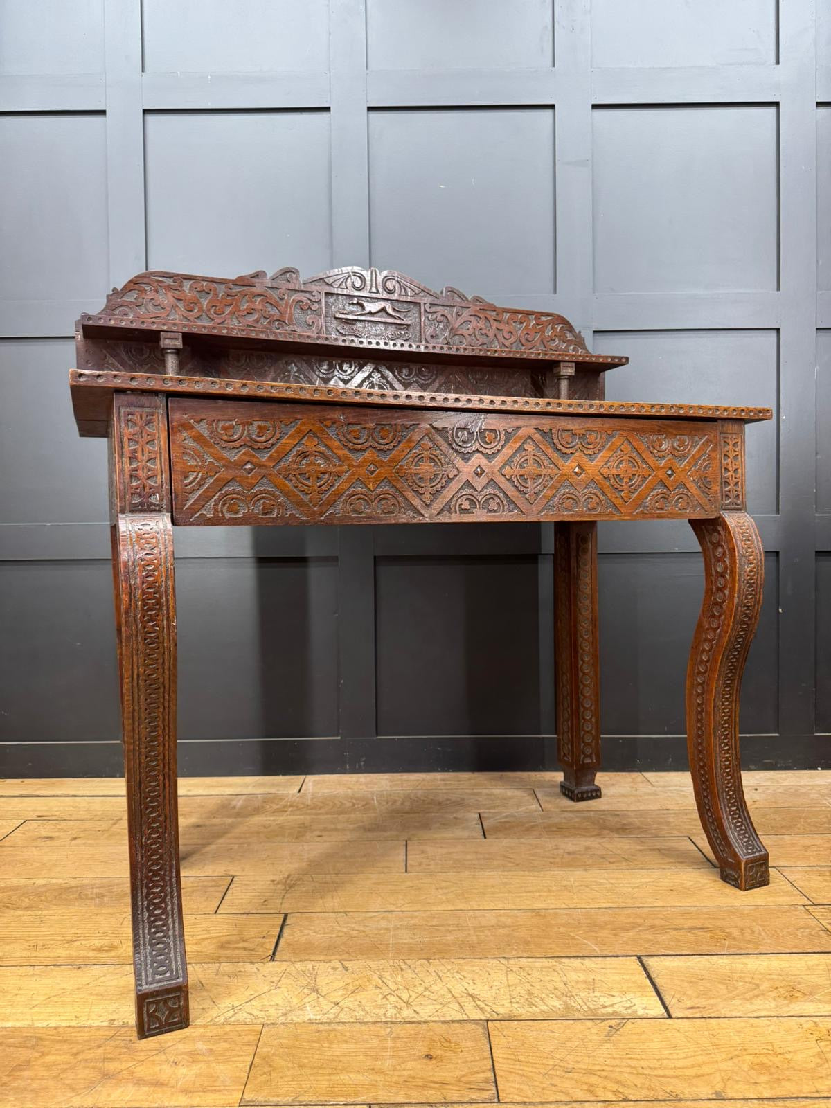 Antique anglo-indian carved oak hall table with intricate geometric and floral patterns in dark brown finish