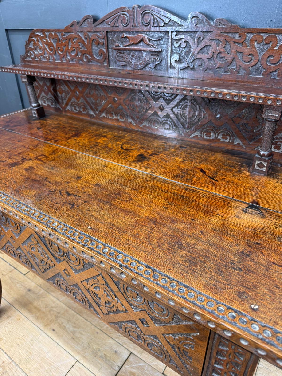 Antique carved oak hall table with dark wood bench featuring ornate detailing and metal studs for hall use