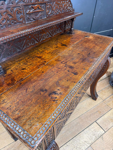 Antique anglo-indian carved oak hall table with intricate carvings and a warm brown finish oak hall table