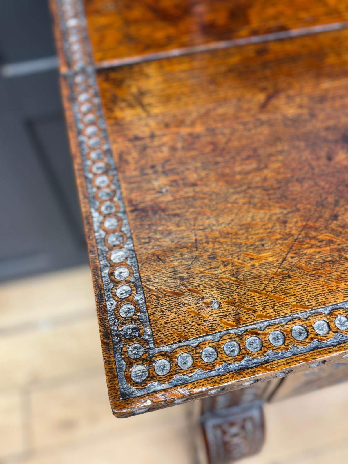 Antique anglo-indian carved oak hall table with warm brown finish and decorative metal inlays along edges