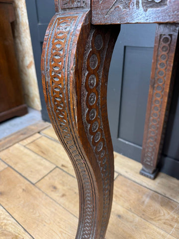 Antique carved oak hall table leg with intricate circular and foliate patterns on oak hall table sideboard