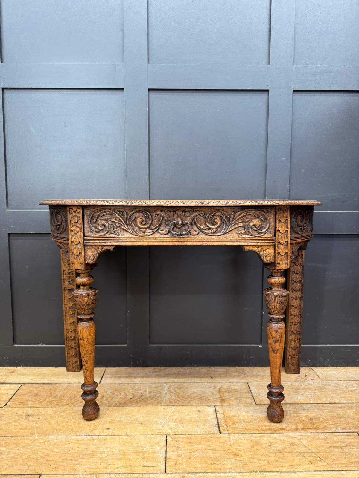 Antique carved oak console table with intricate floral carvings and turned legs perfect for hall or desk use