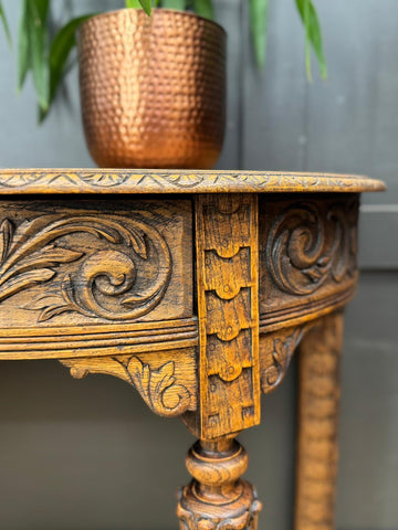 Antique carved oak console table with intricate floral carvings and warm golden-brown finish for hall or desk use