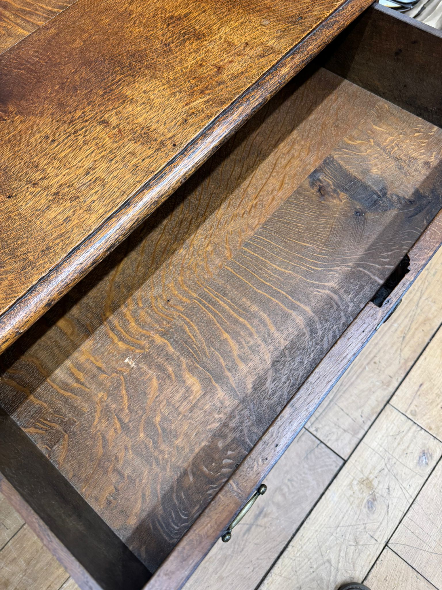Antique carved oak side table with drawer showing rich dark wood grain and metal handle perfect for lamp or hall use