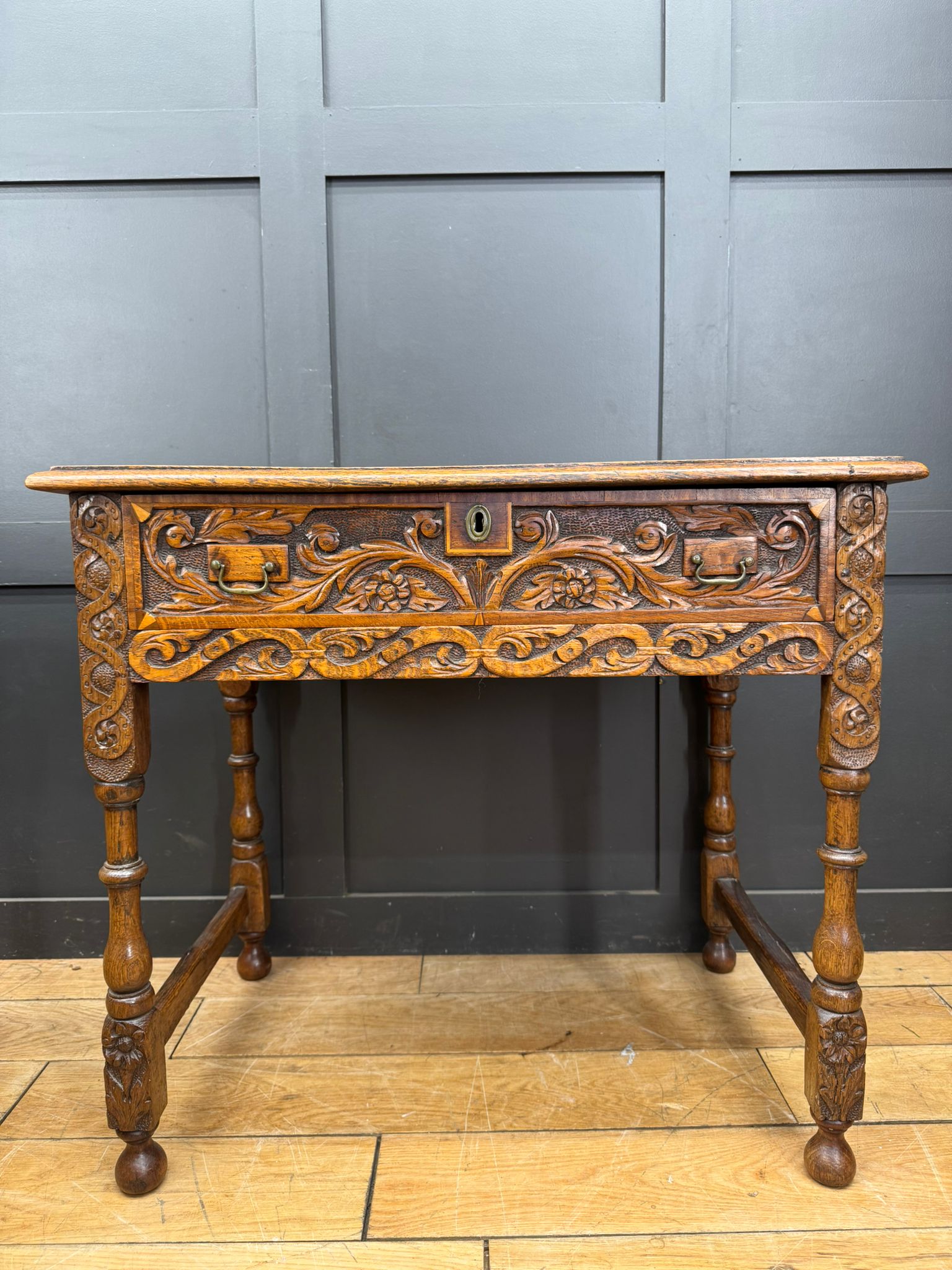 Antique carved oak hall table with drawer featuring intricate floral carvings and turned legs in oak finish