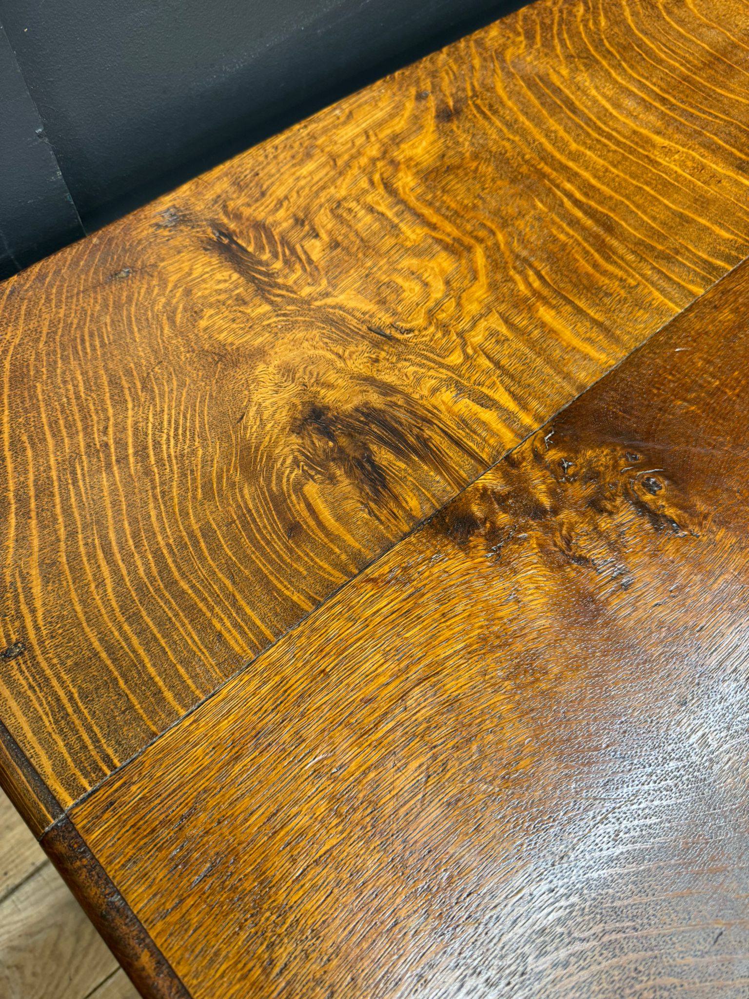 Antique carved oak hall table with rich golden brown tabletop and glossy finish showcasing natural wood grain patterns