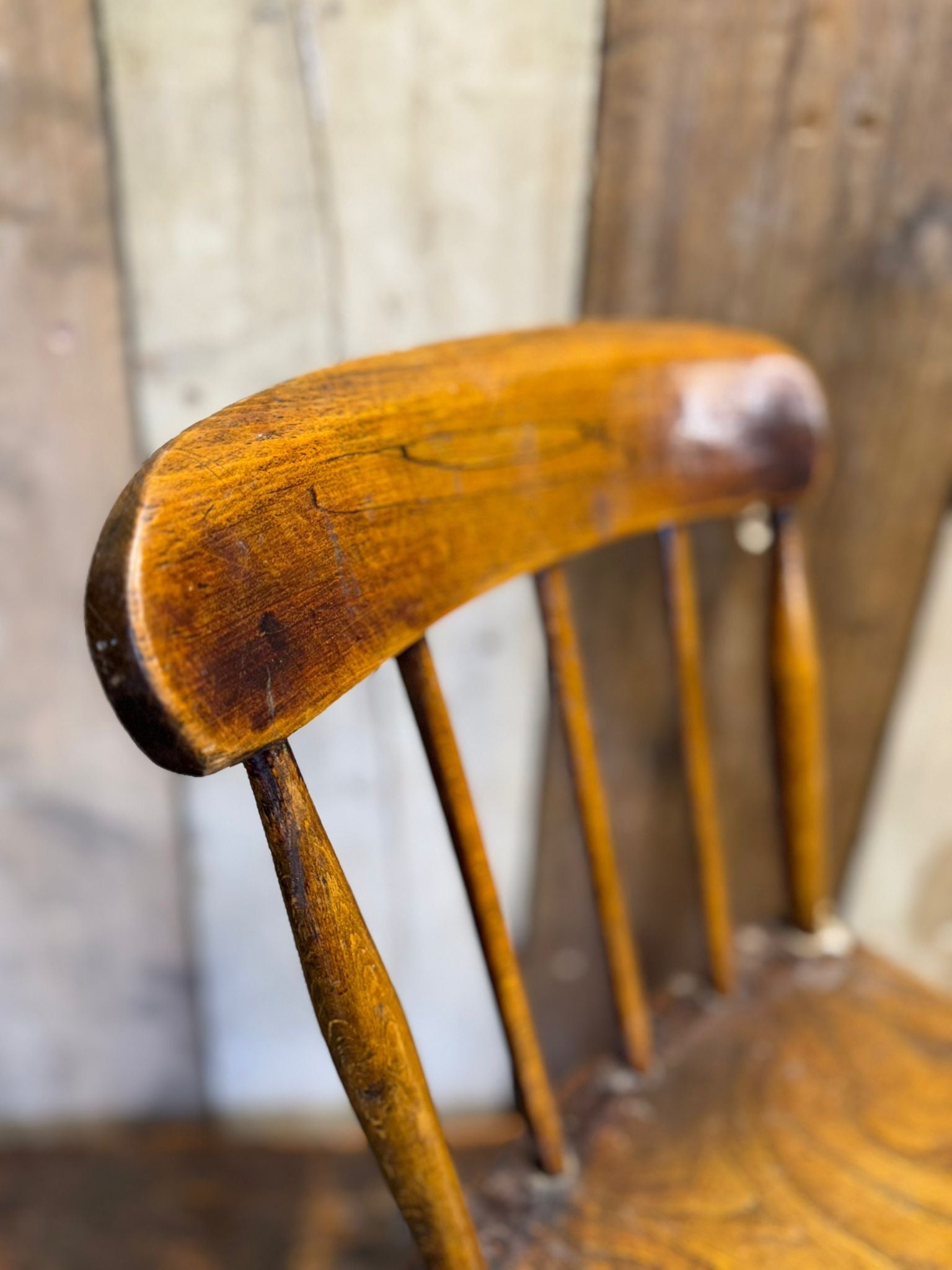 Antique child’s chair with elm seat in warm amber brown wood finish showing visible grain patterns