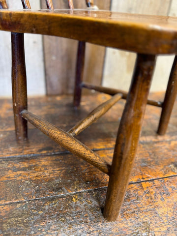Antique child’s chair with warm polished wooden frame and elm seat perfect as nursery book display or plant stand