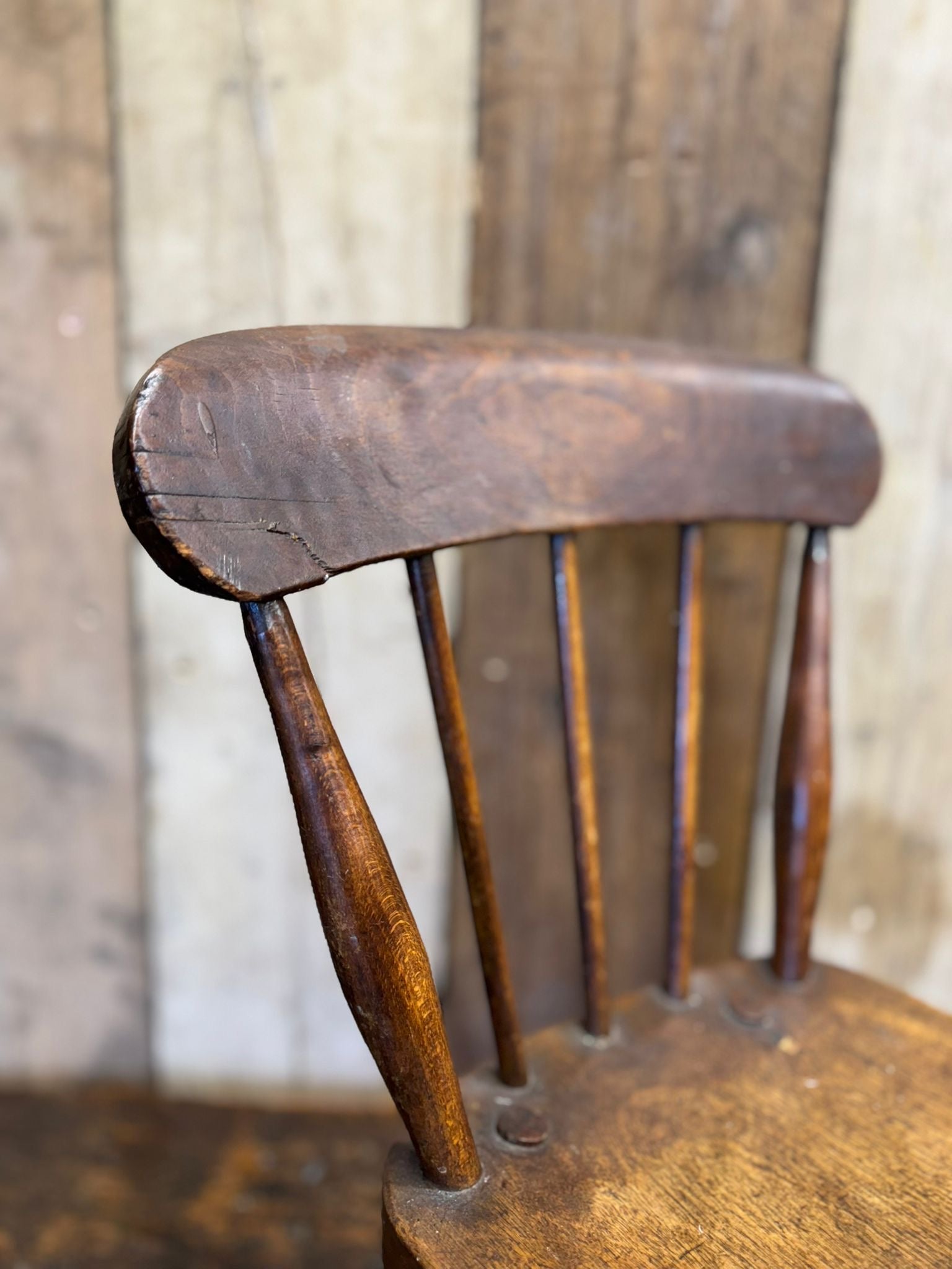 Antique child’s spindle-back chair with dark wood finish and oak seat perfect for nursery or plant stand use