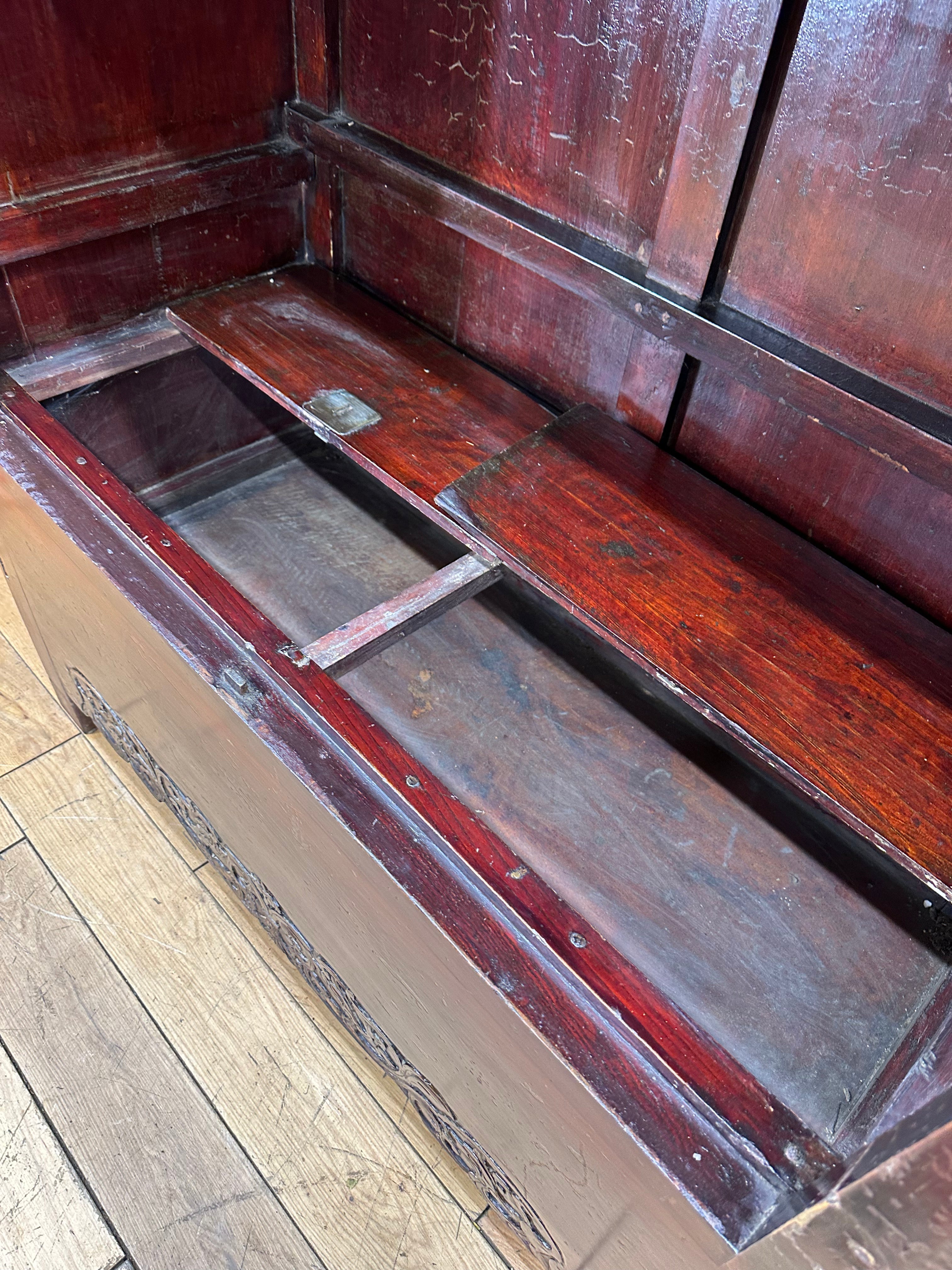 Antique chinese open wedding cabinet in reddish-brown wood with carved detailing and visible wear for display use
