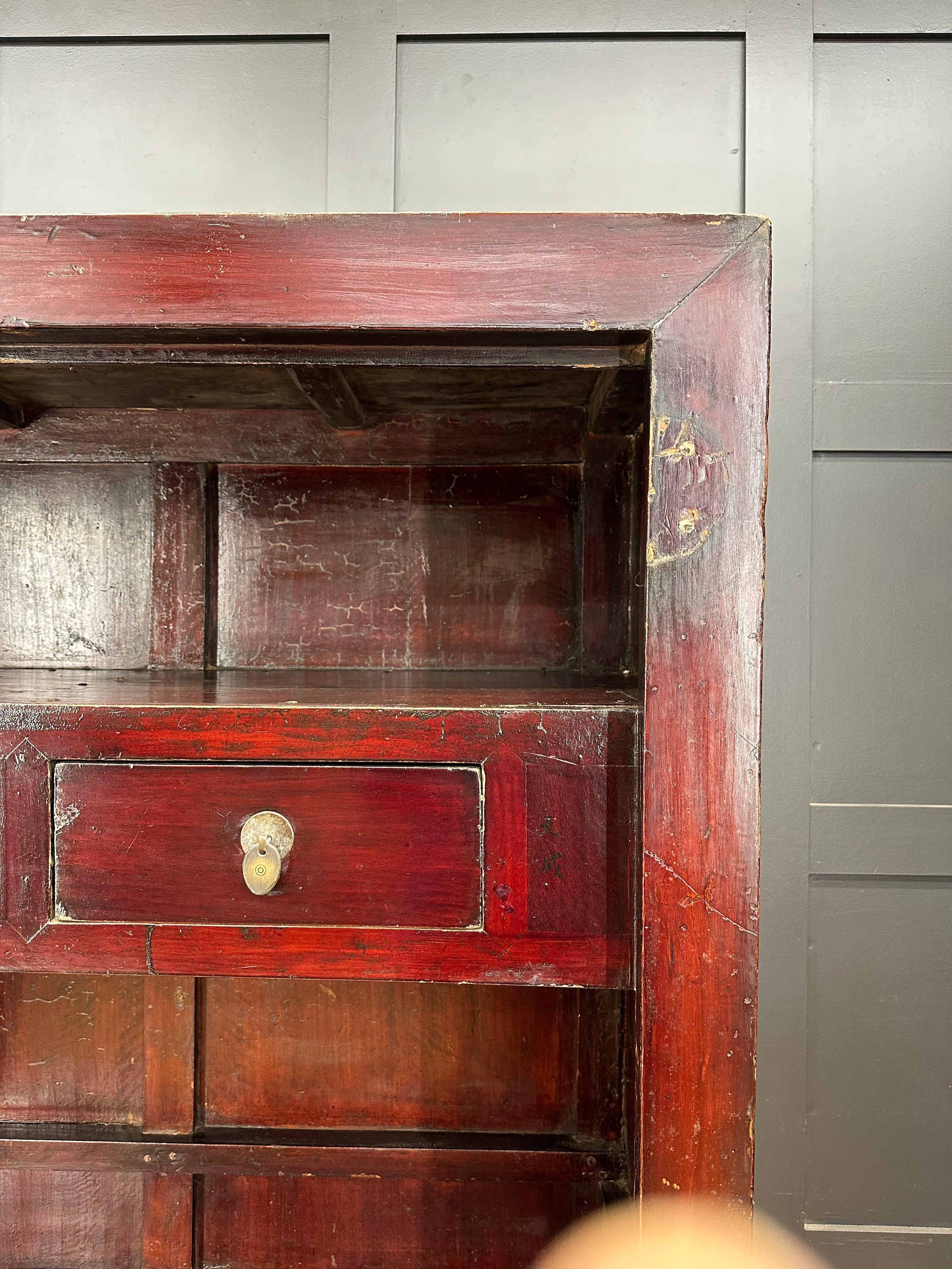 Antique chinese red lacquered wooden wedding cabinet with single drawer and visible wear perfect for display