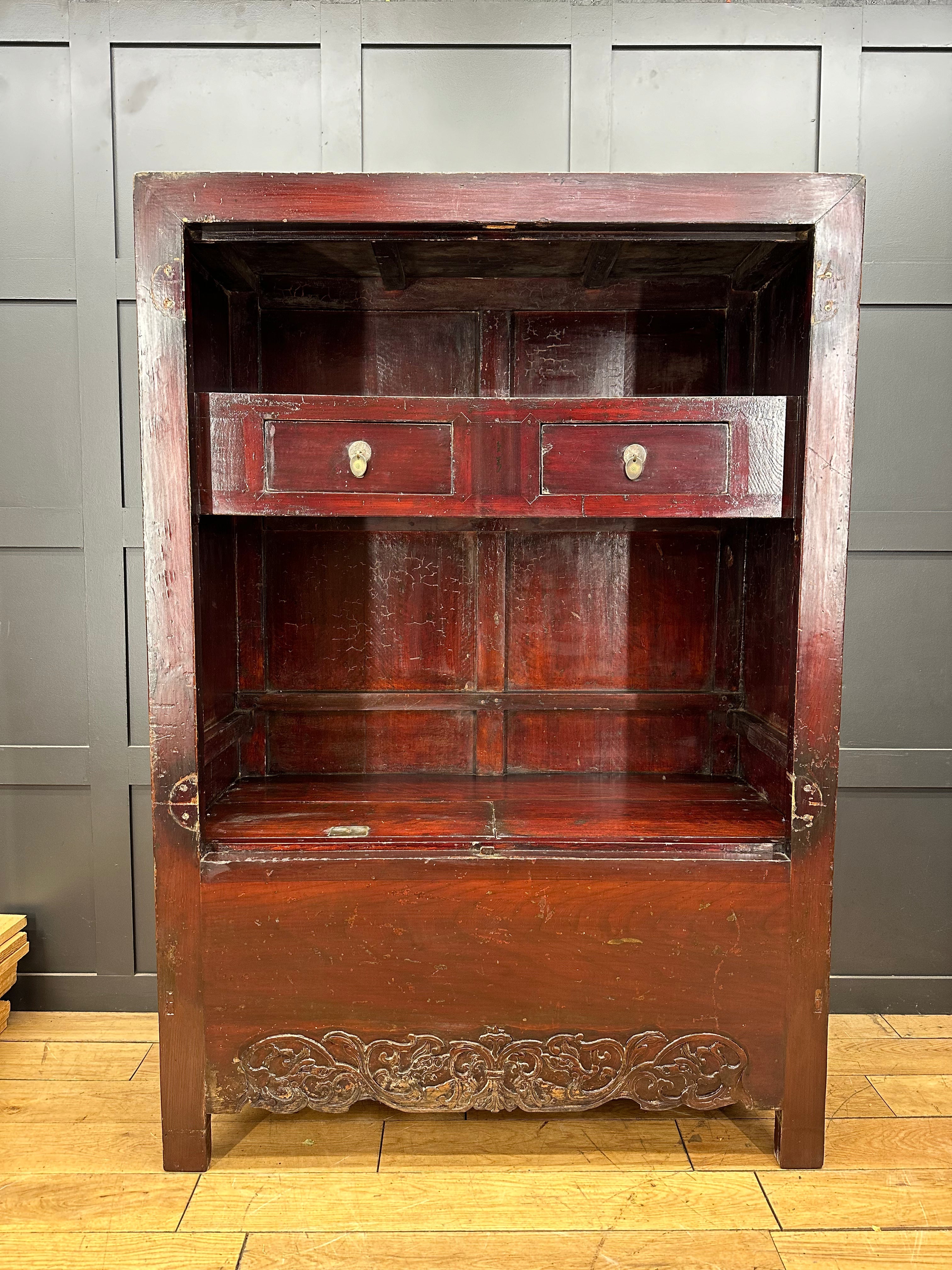 Dark reddish-brown wooden antique chinese wedding cabinet with two drawers and ornate carved base for display or bookcase