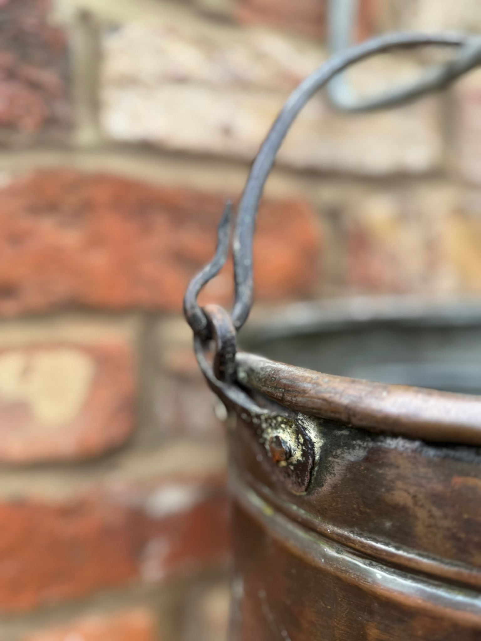 Rustic antique copper cauldron pot with weathered patina finish and twisted wire handle for planter use