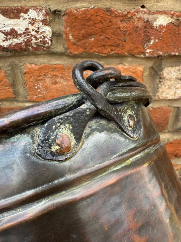 Antique copper cauldron pot with dark patinated finish and ornate riveted iron handle for planter use