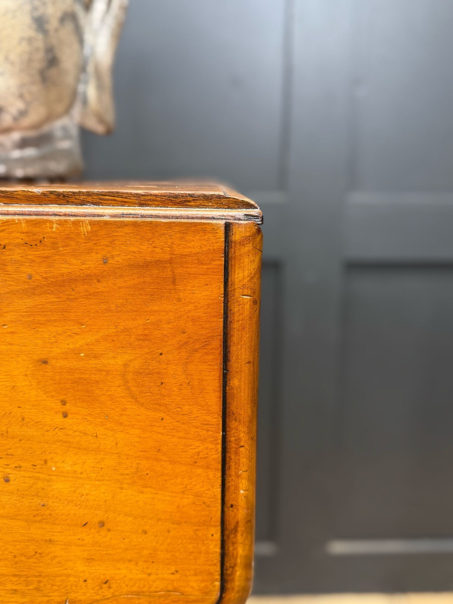 Antique extending mahogany pembroke drop leaf sideboard with drawer showing oak wood cabinet corner with amber finish