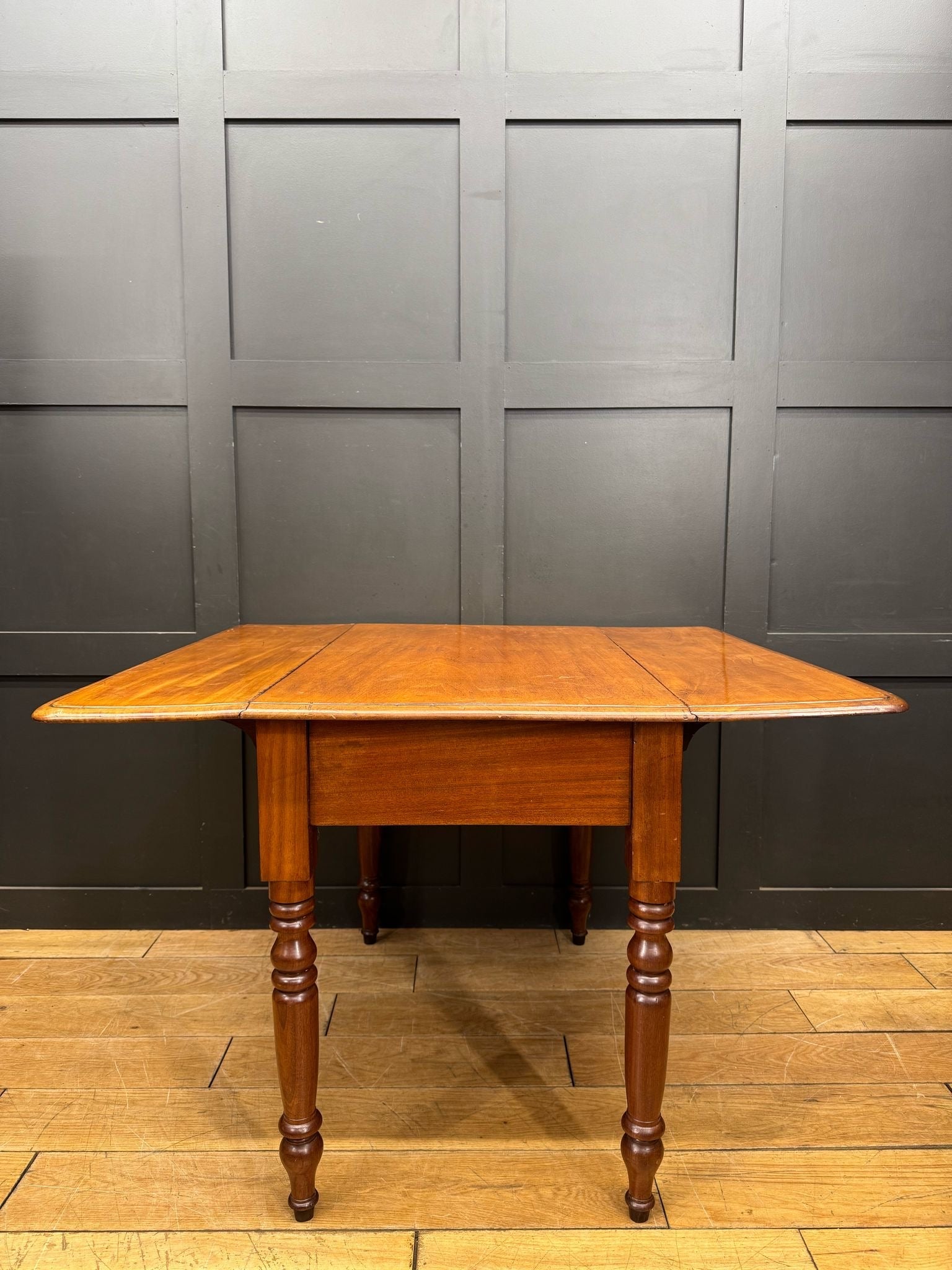 Antique extending mahogany pembroke table with drop leaf, drawer, turned legs, and warm smooth wood finish