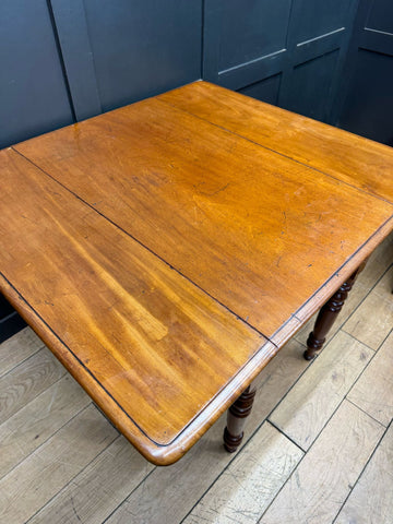Antique mahogany drop leaf pembroke table with warm amber finish turned legs and drop leaf sideboard drawer