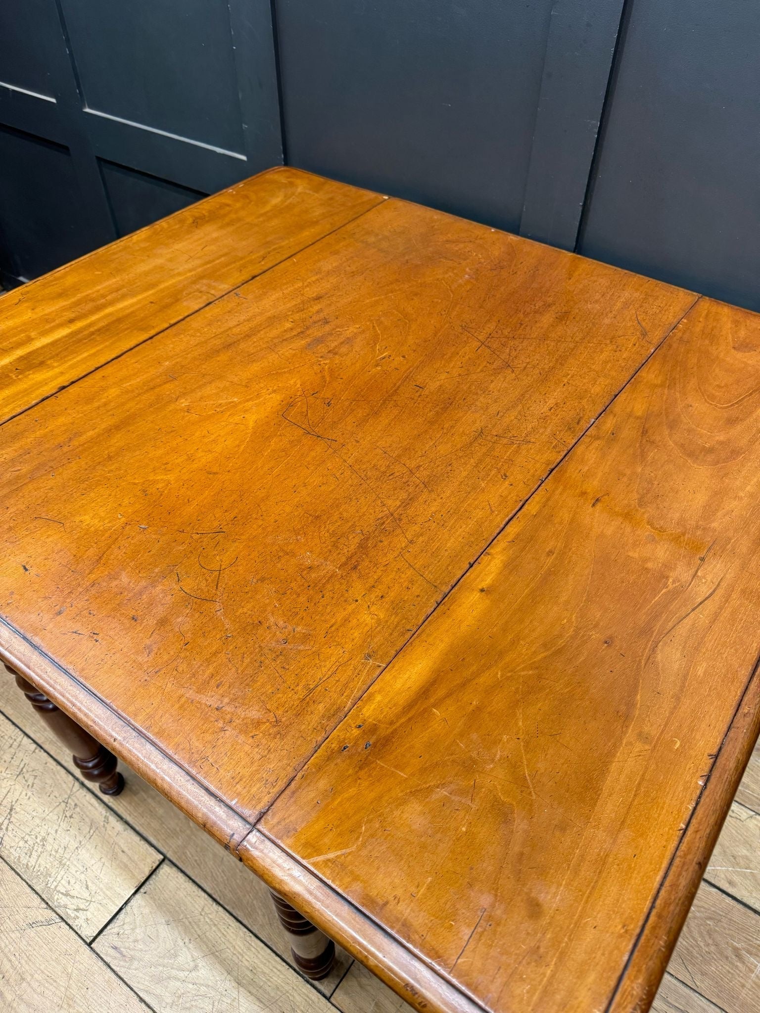 A warm amber finished mahogany antique extending pembroke table with drop leaf and smooth polished surface