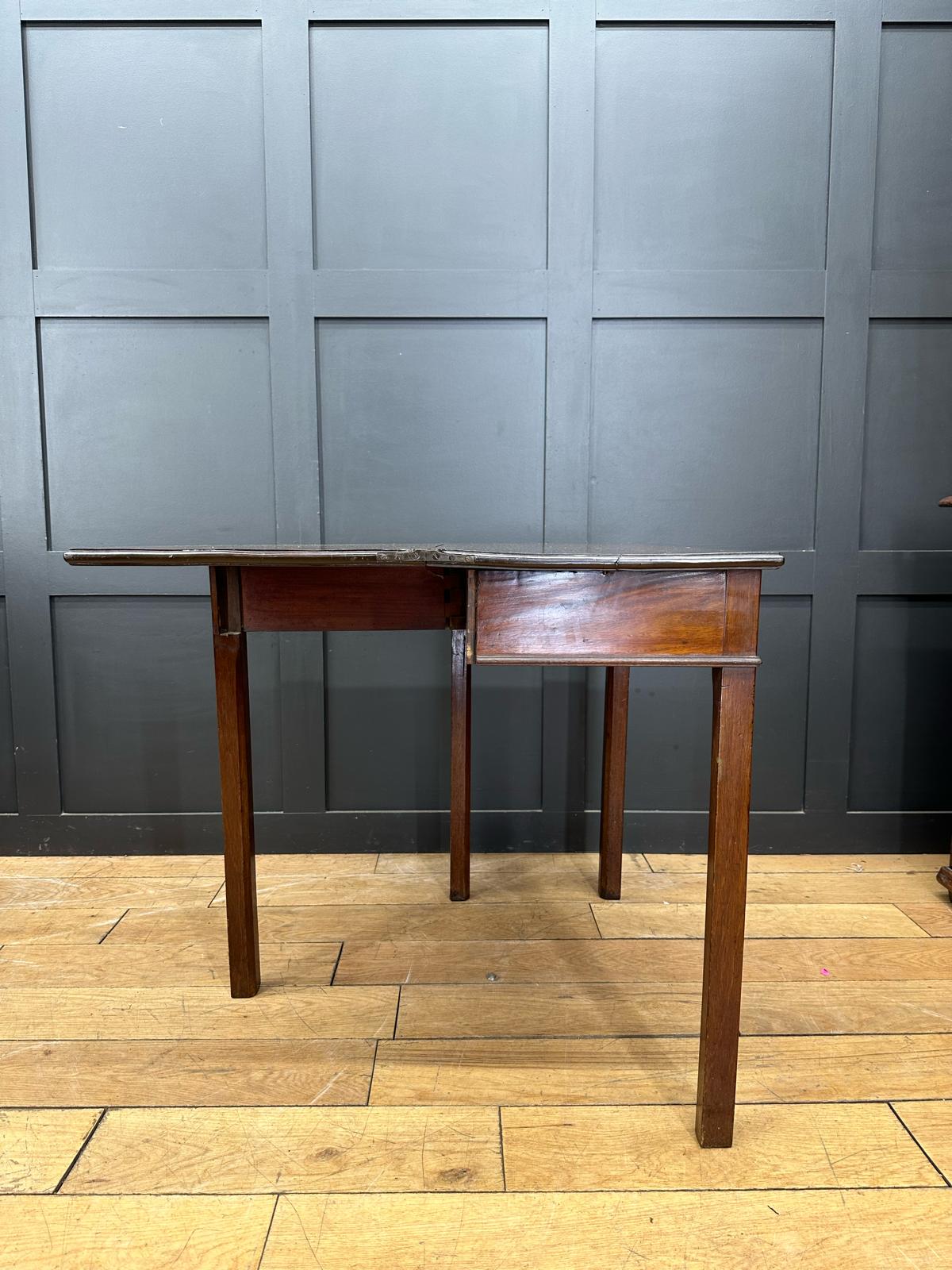 Antique extending mahogany tea table with drop-leaf design and classic wooden legs in warm brown finish