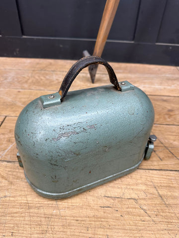 Vintage teal metal cowbell with worn black leather handle for antique hall brothers industrial surveying instrument use