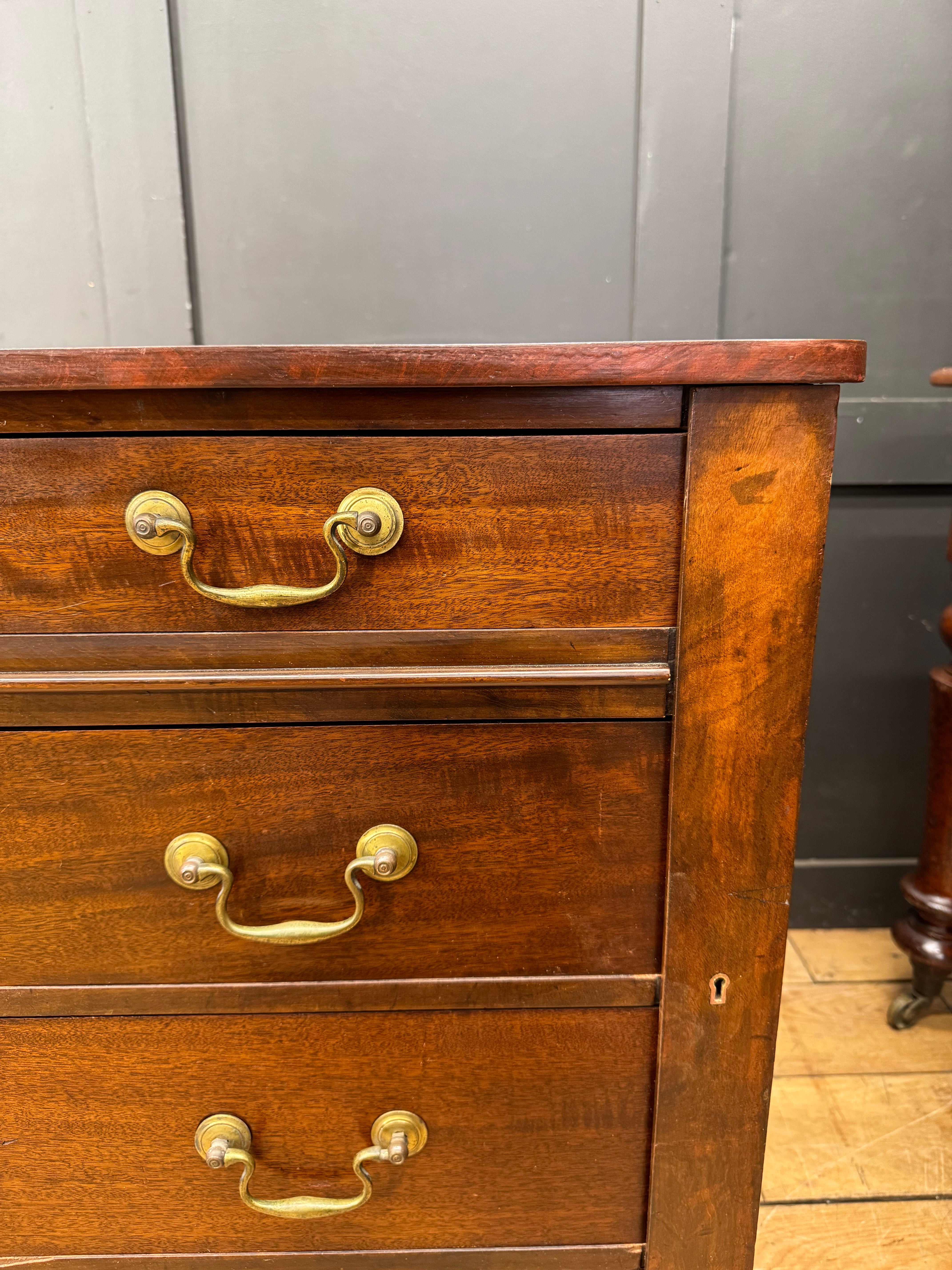 Antique mahogany twin pedestal desk with mahogany chest of drawers featuring brass handles and side keyhole