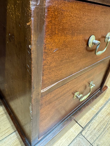 Antique mahogany twin pedestal desk with two wooden drawers featuring brass handles and vintage wear marks