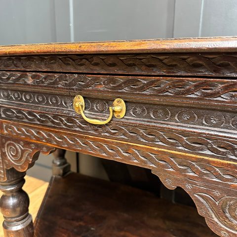 Antique oak credence table with dark wood, intricate carvings, and brass handle perfect as a sideboard or lamp table