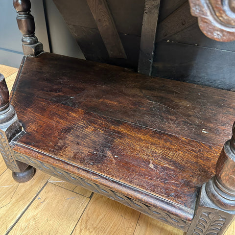 Dark brown oak credence table bench with carved legs and woven pattern along the front edge