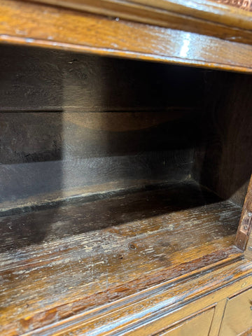 Antique oak cupboard with dark worn finish and visible surface wear from 18th century used as tv stand