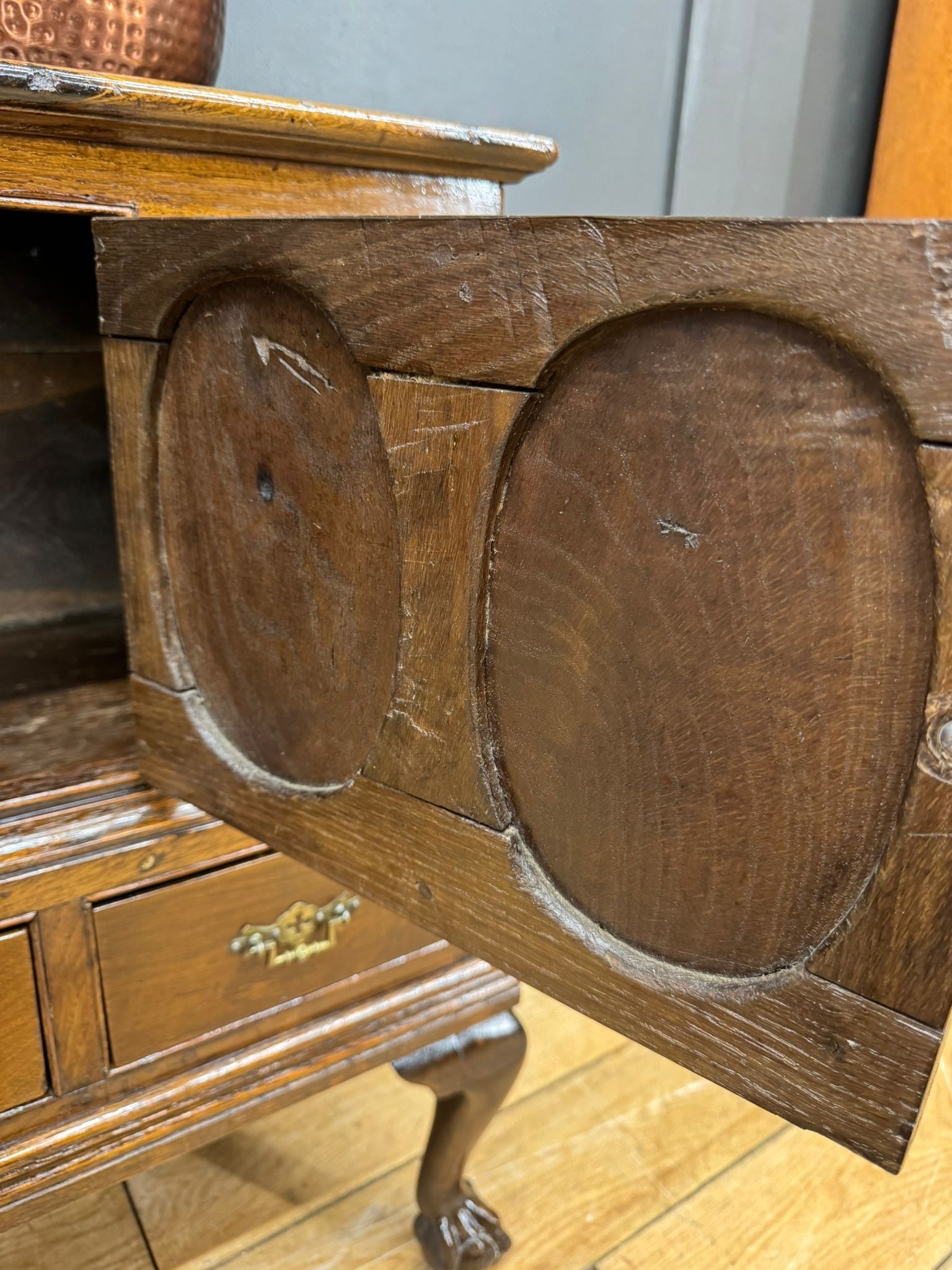 Antique oak cupboard sideboard with carved oval panels brass hardware and slight surface wear from 18th century
