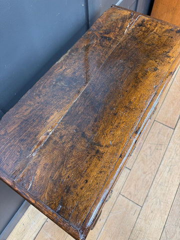 Antique oak cupboard with rich dark brown finish and visible grain patterns showing surface wear from 18th century