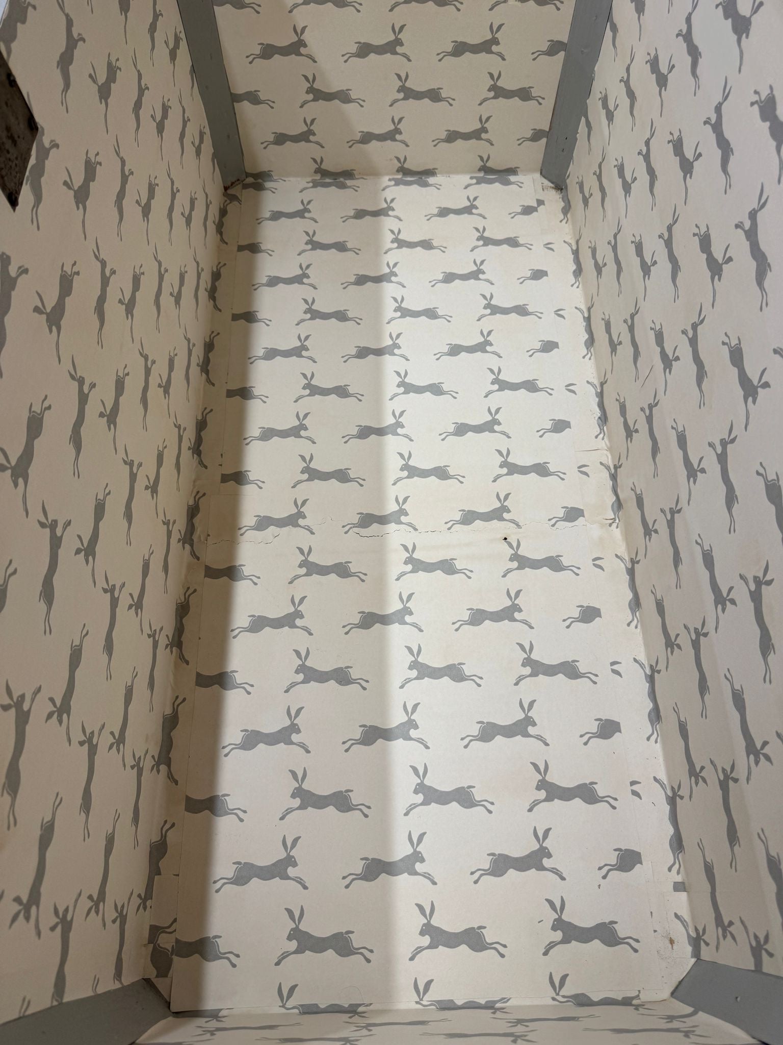 Antique painted blanket chest lined with cream wallpaper featuring gray hares ideal for shoe storage or toy bench