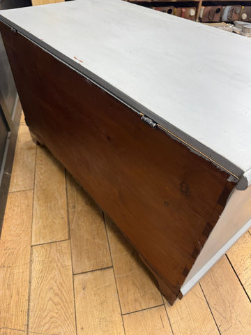 Vintage wooden blanket chest with white painted top and dark wood sides featuring metal hinges for shoe storage