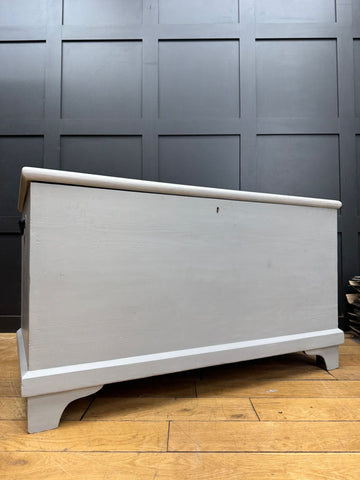 Light gray painted wooden blanket chest with classic design and curved edges for shoe storage and toy organization