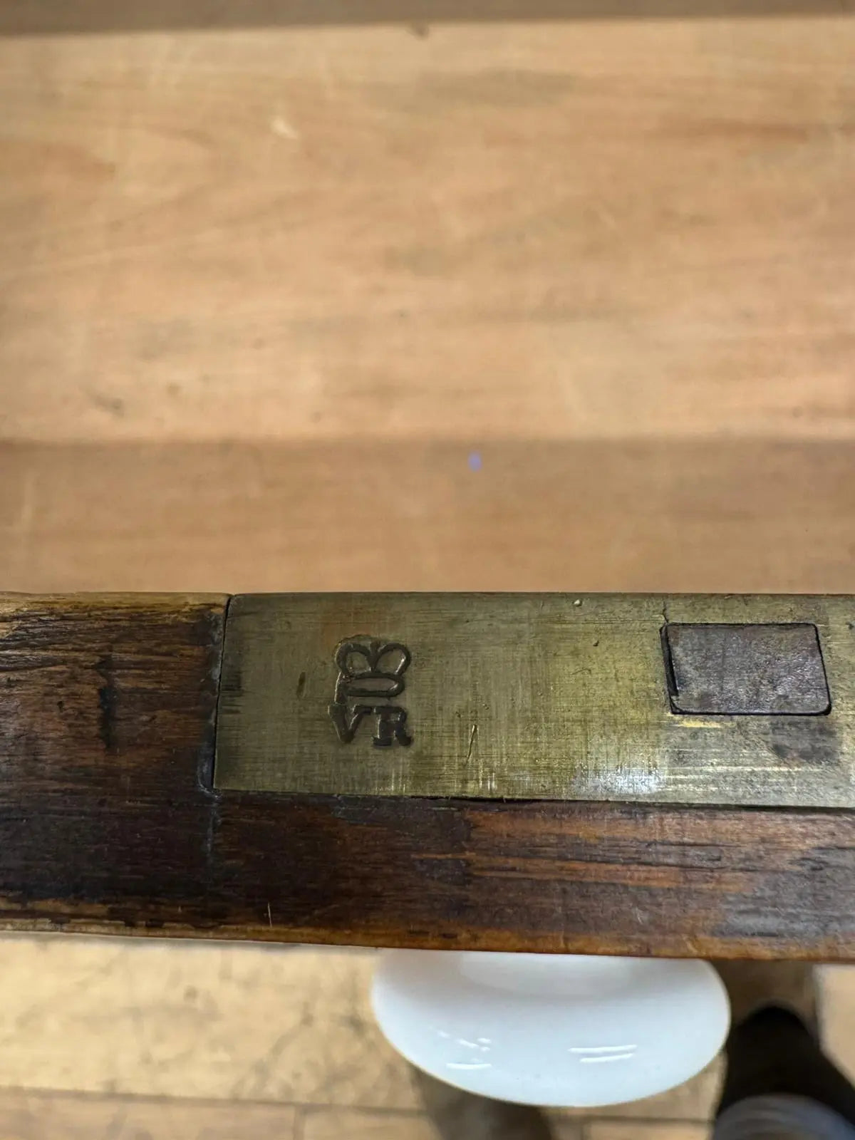 Antique brass rifle barrel with engraved crown and vr insignia alongside a pine chest for country house storage