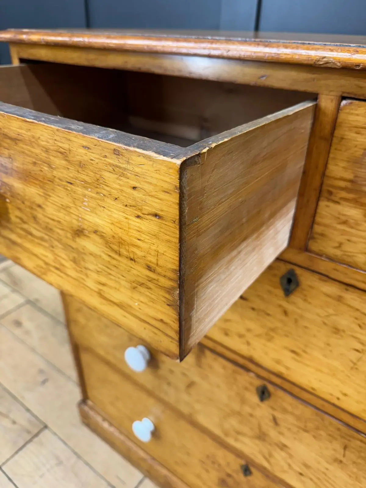 Antique pine chest of drawers with warm golden oak finish and light round knobs for country house storage