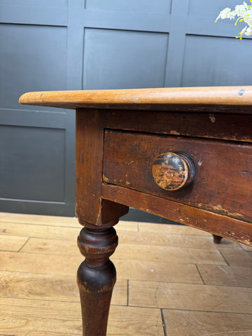 Antique pine kitchen table with a distressed dark brown finish, single drawer, round knob, and turned legs